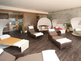 Indoor Ruhebereich der Saunalandschaft im Hotel Der Westerhof mit Ruheliegen, Handtuechern und Relax-Muscheln